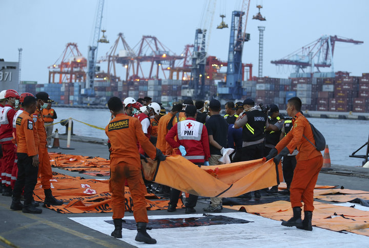 Officials examine victims recovered from the Lion Air jet that crashed into Java Sea on Monday at Tanjung Priok Port in Jakar