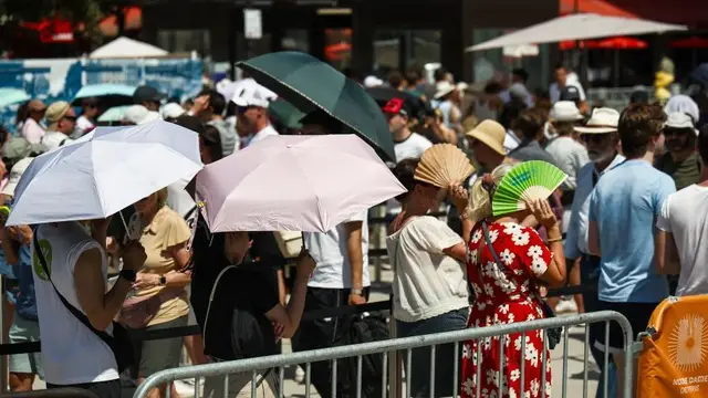 People use umbrellas and fans to protect themselves from the sun on the parvis of Notre-Dame de Paris cathedral during a heatwave in Paris, Ile-de-France, France, on June 22, 2026. Des personnes utilisent des parapluies et des eventails pour se proteger du soleil sur le parvis de la cathedrale Notre-Dame de Paris lors d une vague de chaleur a Paris, Ile-de-France, France, le 22 juin 2026. (Photo by Gauthier Bedrignans / Hans Lucas / AFP via Getty Images)